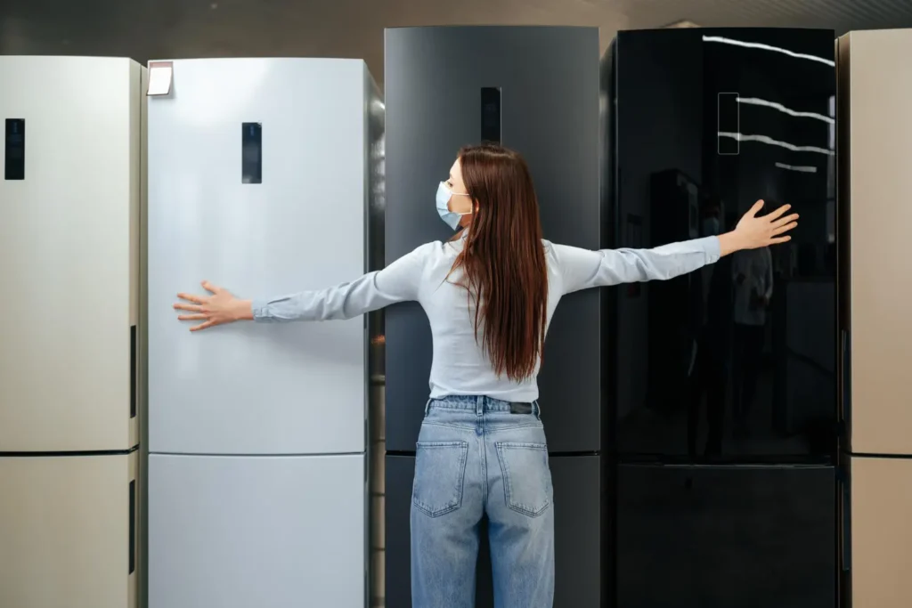 Woman comparing different refrigerators in an appliance store