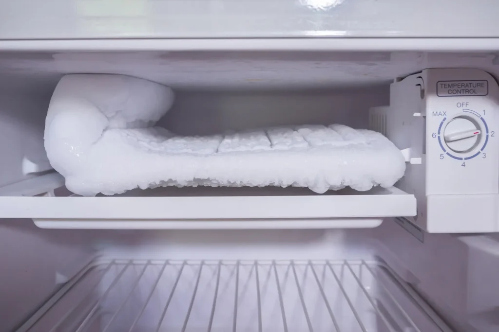 Refrigerator freezer with heavy ice buildup on the cooling compartment