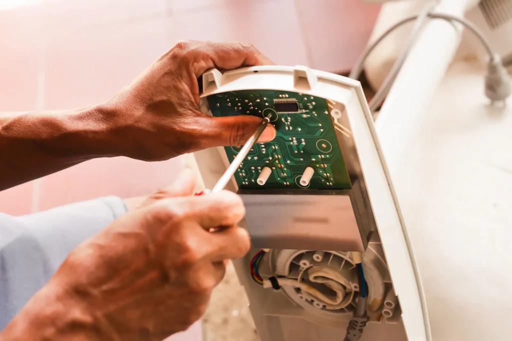 Man repairing a washing machine circuit board