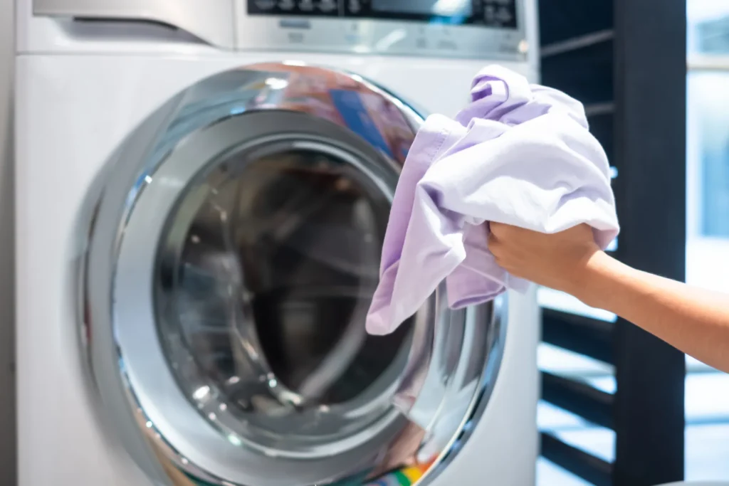Woman loading clothes into a washing machine