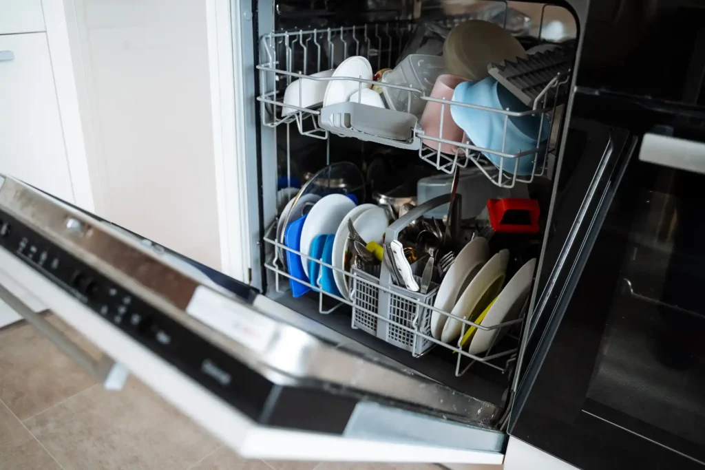 Dishwasher loaded with plates, cups, and utensils